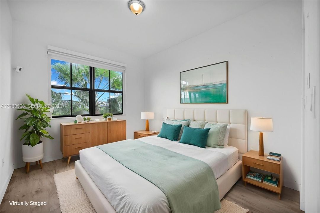 Wood-finish flooring, multi-pane window with black framing, and flush-mount ceiling light fixture