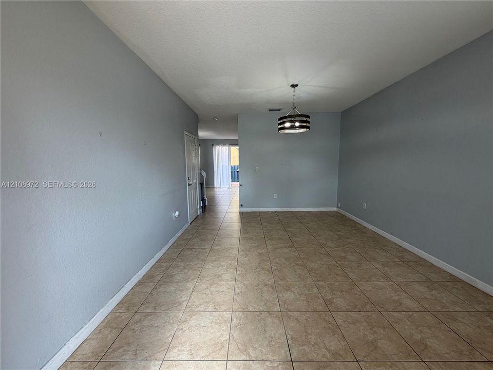 Interior space featuring ceramic tile flooring, neutral wall paint, and a drum-style ceiling light fixture