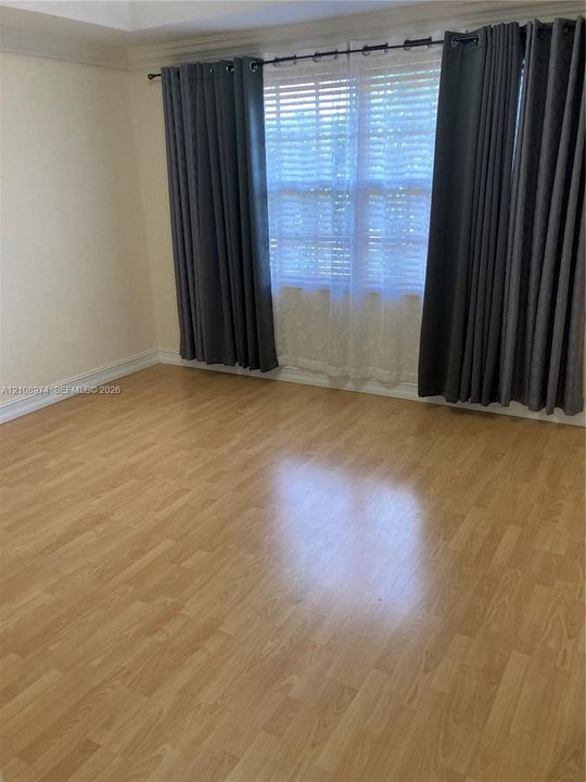 Room featuring wood-finish flooring and crown molding
