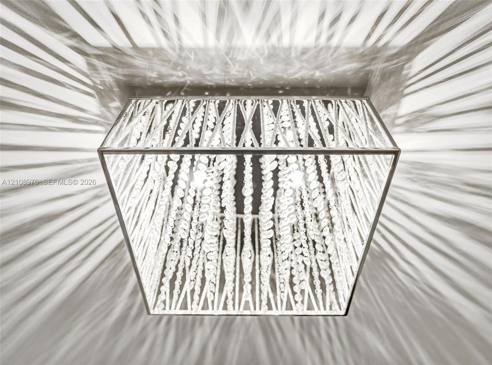 Square flush-mount ceiling fixture featuring a metallic frame and cascading crystal bead strands