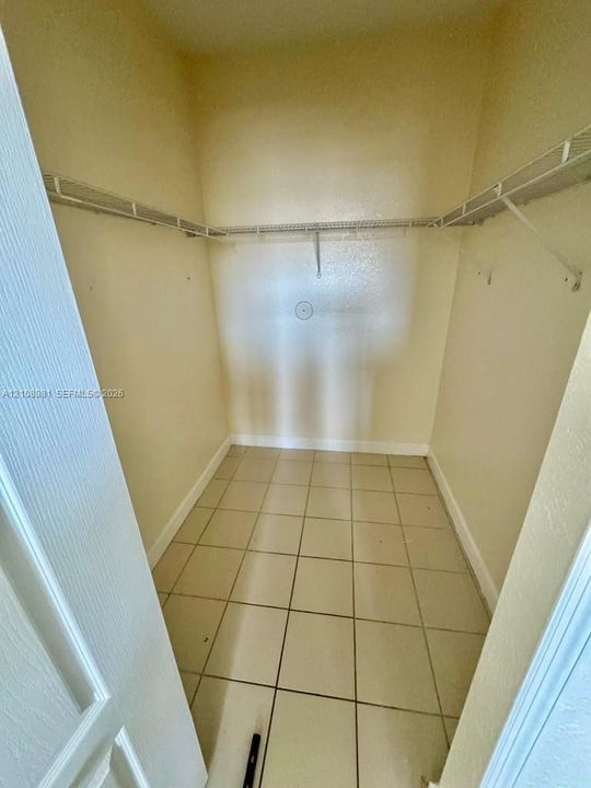 Walk-in storage space featuring ceramic tile flooring and white wire shelving
