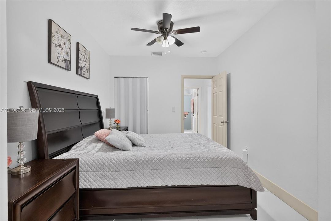 Room featuring a ceiling fan with integrated light fixture and a folding closet door