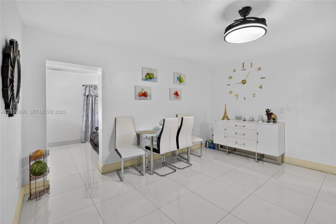 Bright room featuring white tile flooring, neutral walls, and a modern ceiling-mounted fixture with integrated lighting