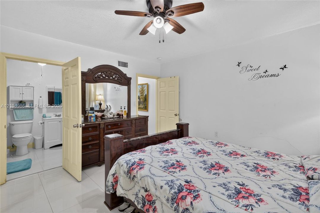 Bedroom featuring polished tile flooring, a multi-blade ceiling fan with integrated lighting, and a neutral color palette