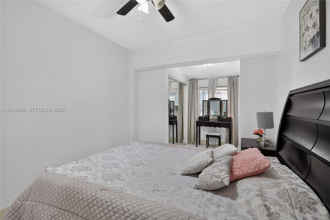 Neutral interior featuring a ceiling fan with integrated lighting and a closet with sliding mirrored doors