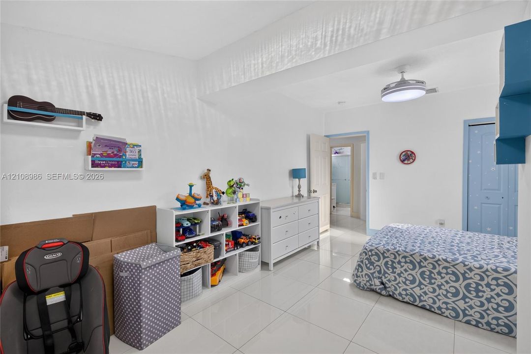 Large-format tile flooring, flush-mount ceiling fixture, and dual-panel closet door