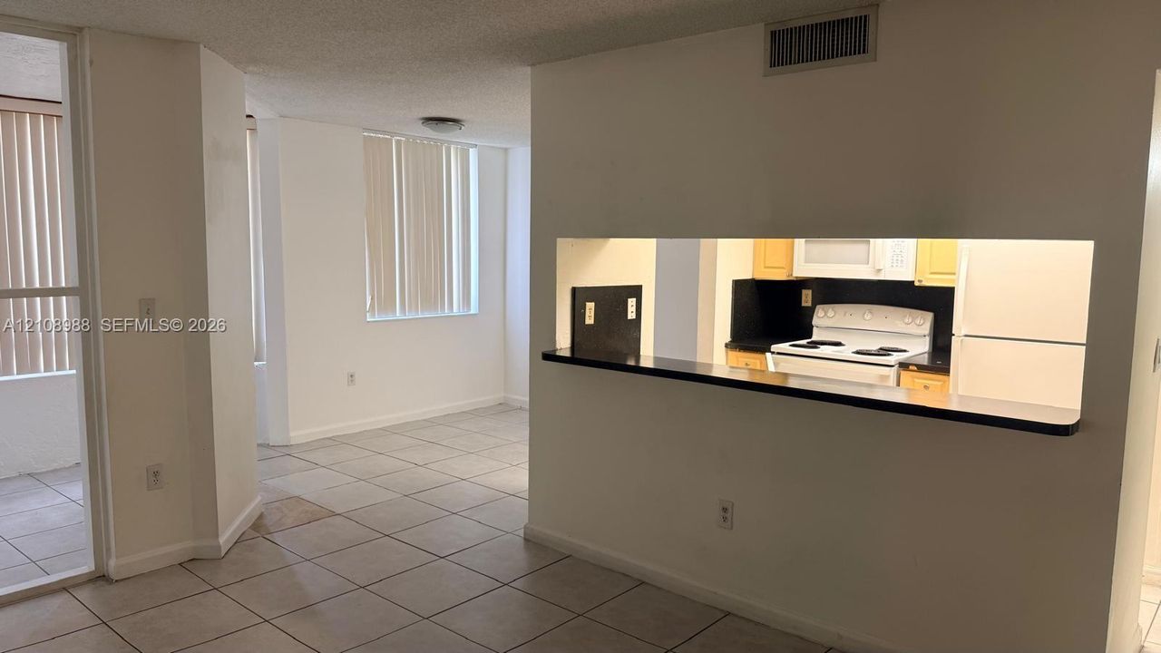 Interior featuring ceramic tile flooring, a pass-through opening, and a flat-surface breakfast bar
