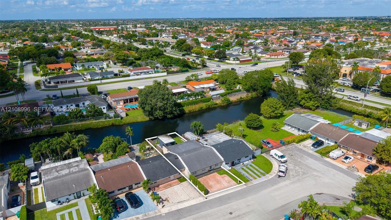 Aerial perspective of a waterfront property featuring a paved driveway and direct canal access
