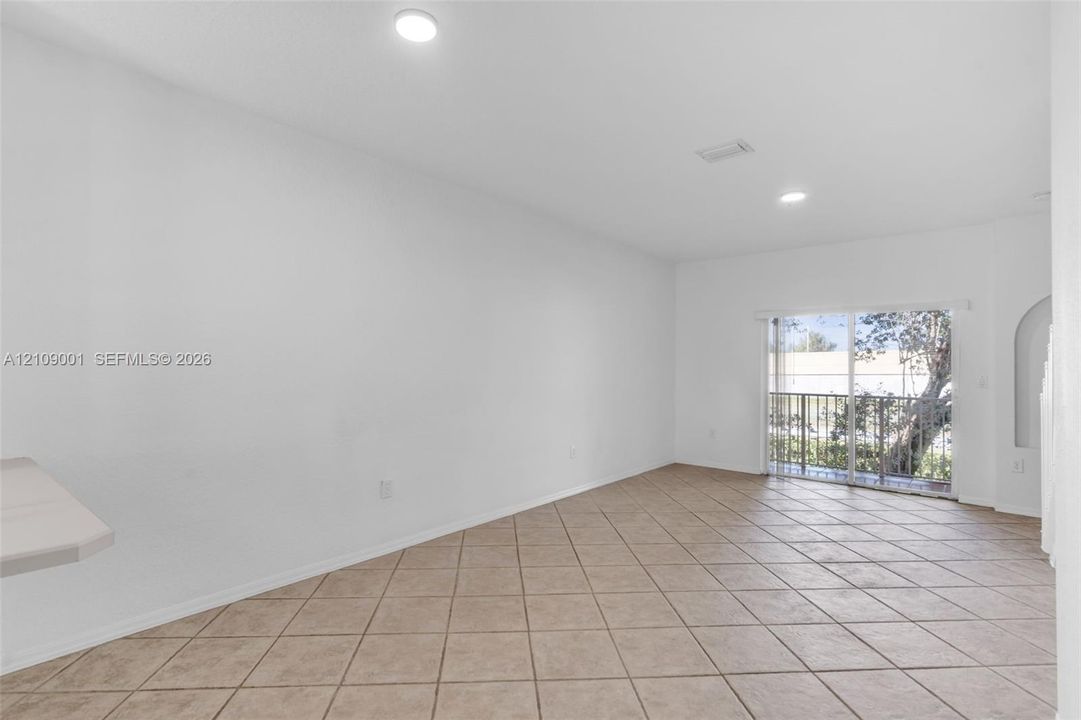Interior space featuring neutral wall paint, tile flooring laid on a diagonal, recessed ceiling lighting, and sliding glass doors with exterior access