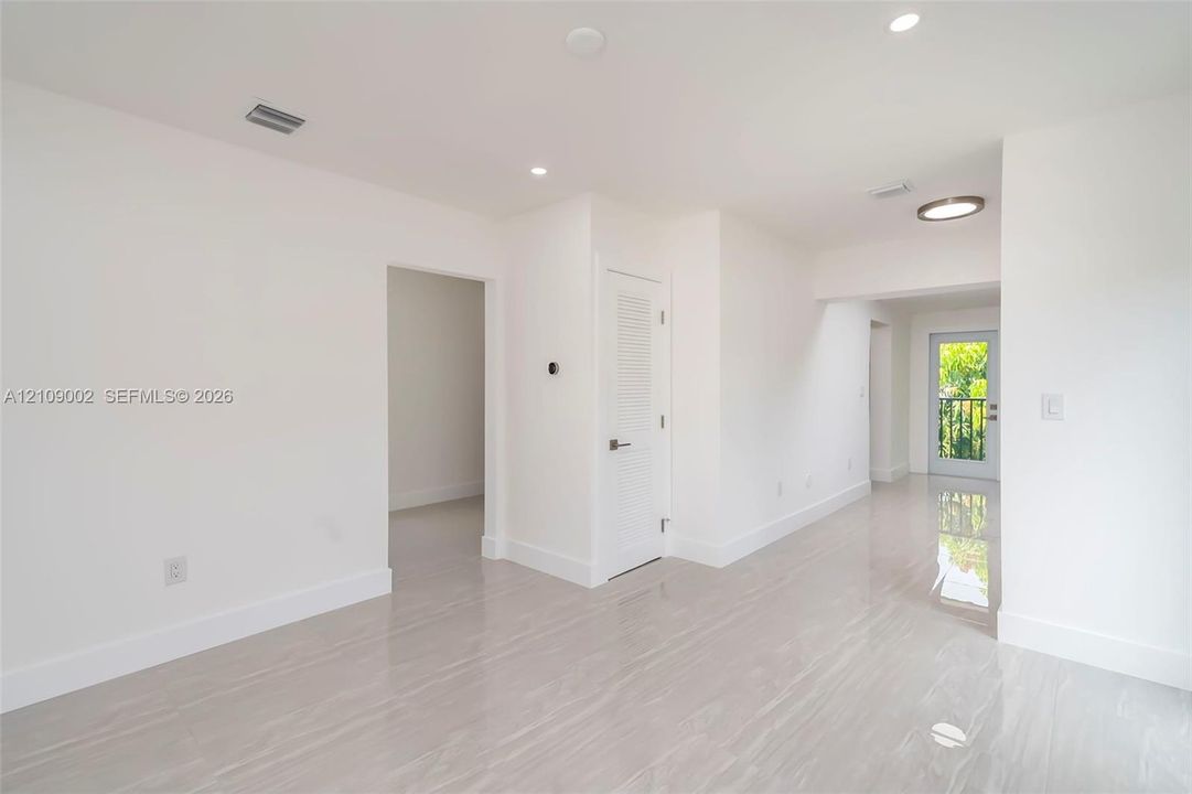 Interior space featuring polished tile flooring, recessed lighting, and a door with glass pane detailing