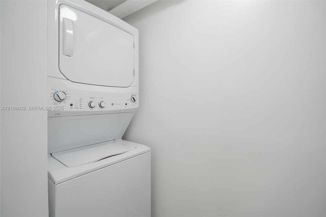 Stacked white laundry appliance unit with dial-operated controls