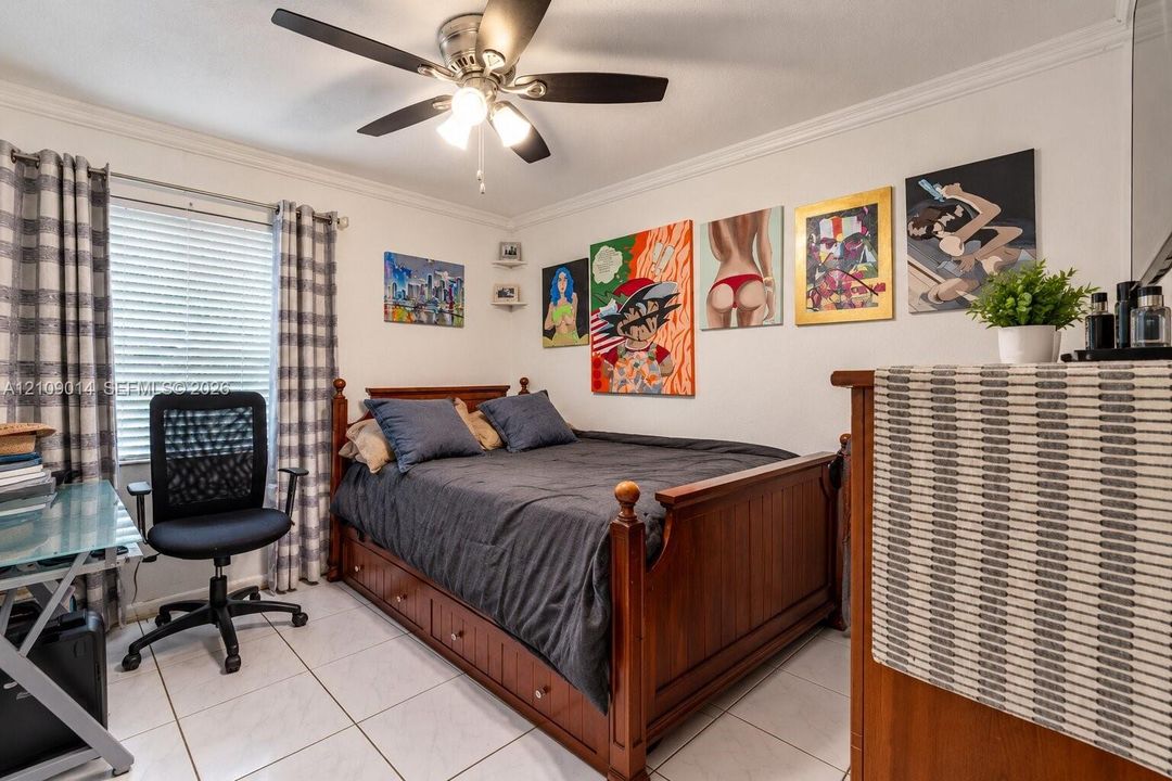 Light-colored tile flooring, crown molding, ceiling fan with integrated light fixture, and corner shelving units