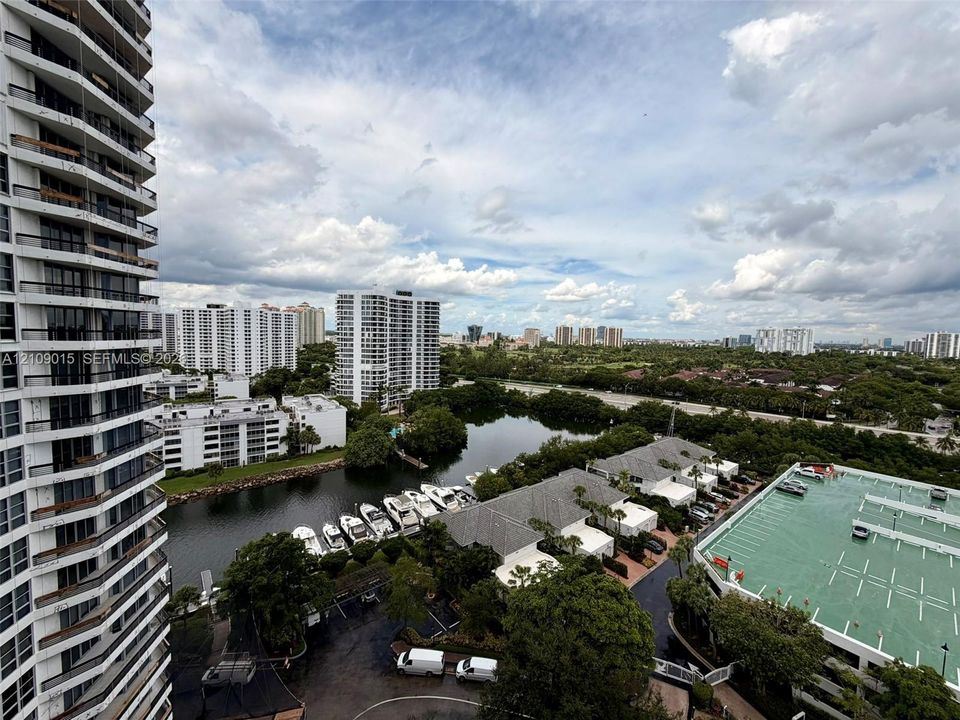 High-rise exterior featuring stacked cantilevered balconies, overlooking a waterway with private boat slips and surrounding residential infrastructure