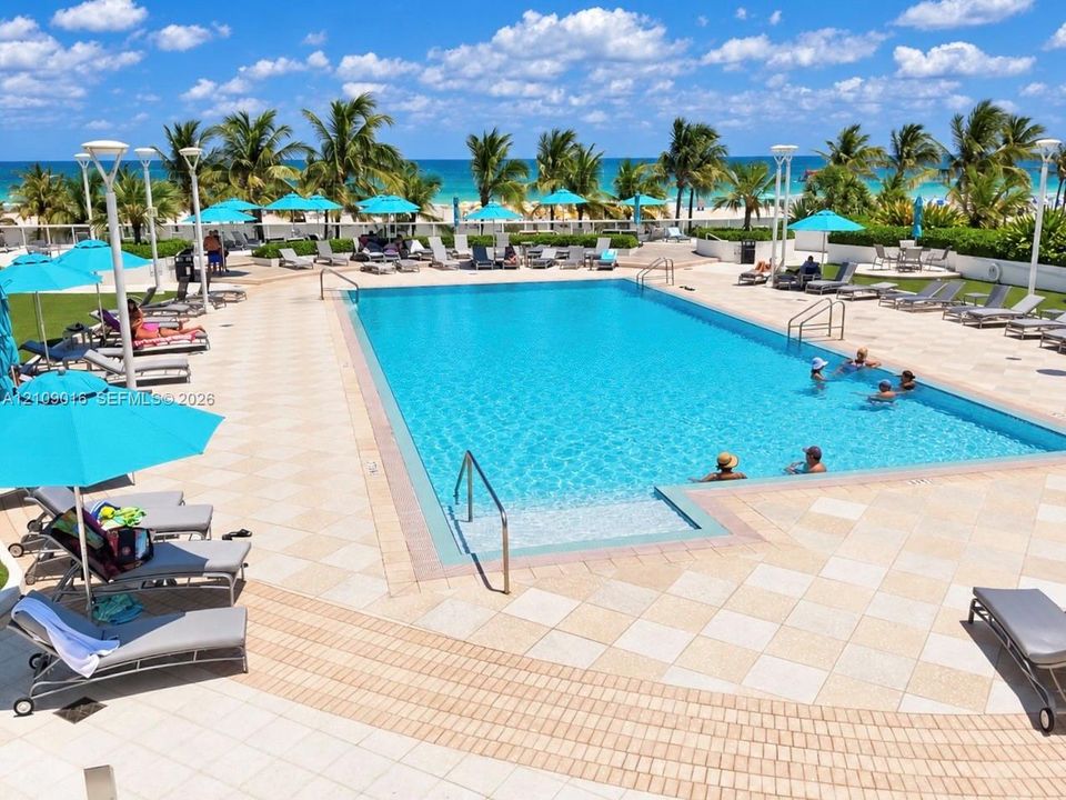 Exterior perspective featuring private balconies, multi-story structural architecture, and direct oceanfront scenery