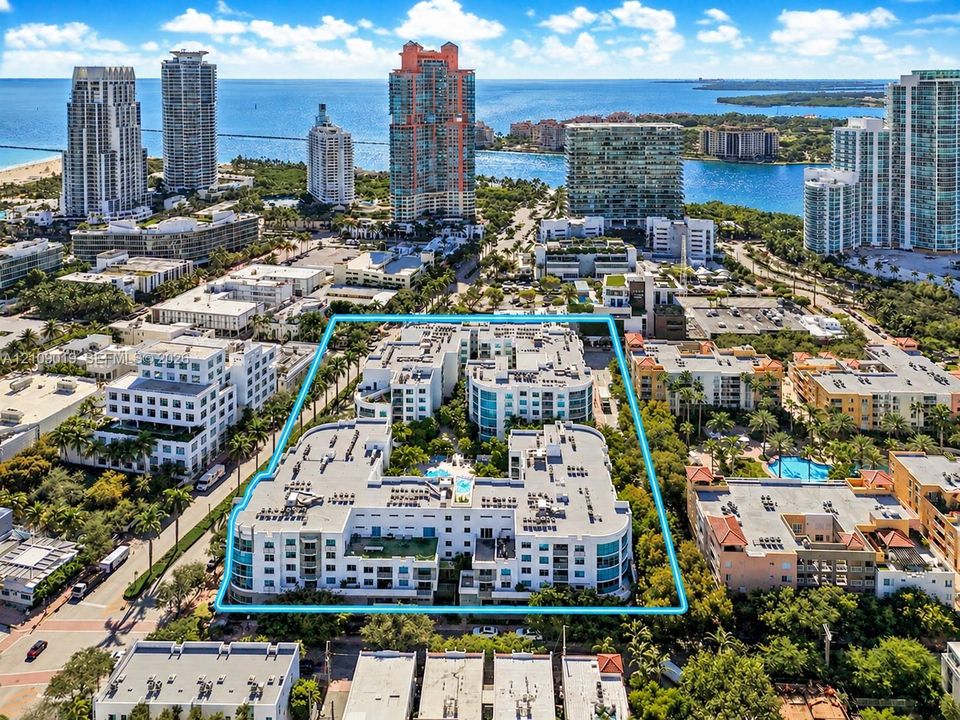 Low-rise multi-story complex featuring a central courtyard pool, roof-level garden terrace, private balconies, and perimeter landscaping