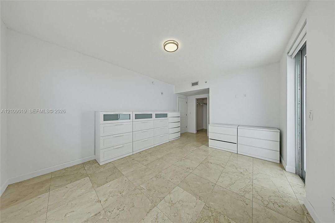 Interior room featuring polished stone tile flooring and a flush-mount circular ceiling light fixture