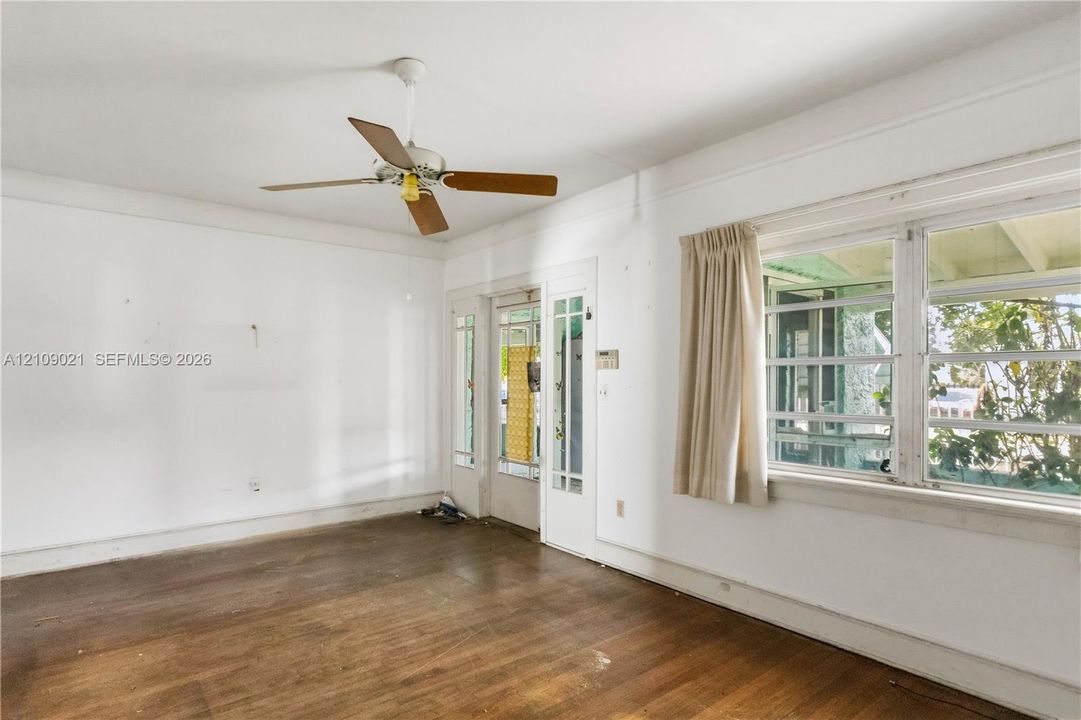 Interior space featuring wood-finish flooring, a ceiling fan, multi-pane window configuration, and an exterior-access door with glass paneling