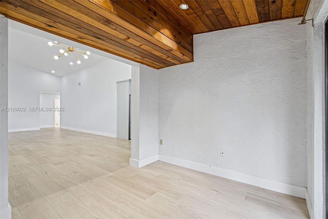 Textured walls, wood-finish flooring, recessed ceiling lighting, and wooden plank ceiling detailing