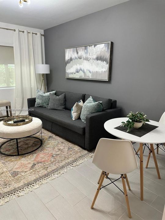 Neutral-toned walls, light-colored tile flooring, and window treatments with ceiling-mounted hardware
