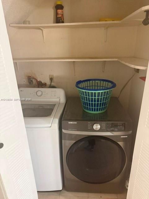 Laundry area featuring louvered bi-fold doors and two levels of built-in shelving