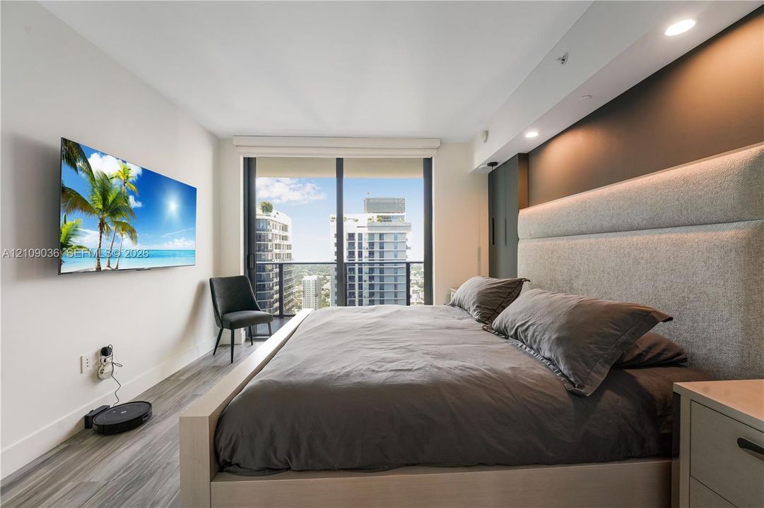 Floor-to-ceiling windows, wood-finish flooring, recessed ceiling lighting, and integrated wall-mounted accent lighting