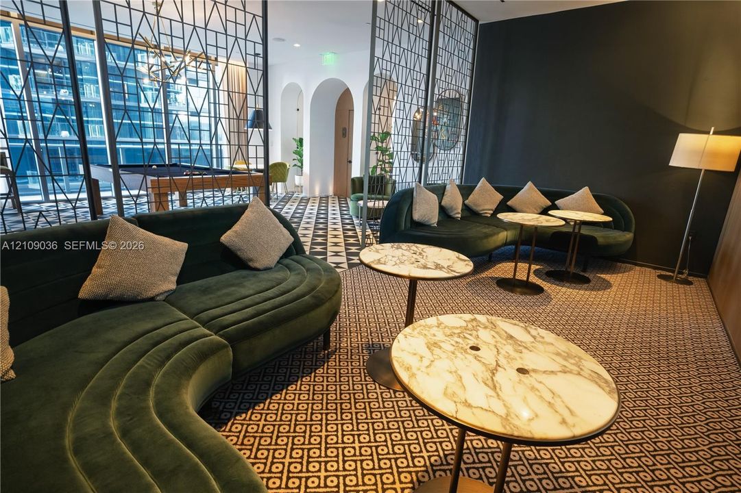 Common area featuring decorative metal room dividers, arched architectural alcoves, and patterned flooring