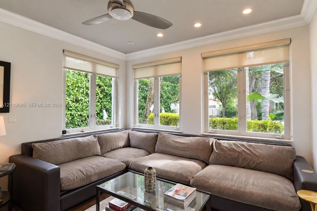 Room featuring triple windows, crown molding, recessed lighting, and a ceiling fan