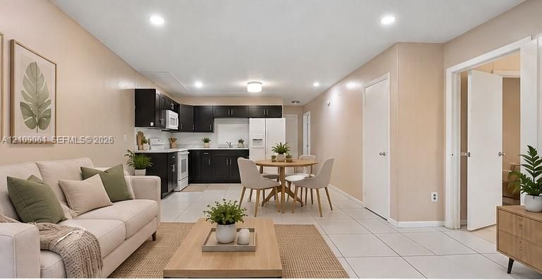 Open floor plan featuring tile flooring, recessed lighting, and dark-finish cabinetry