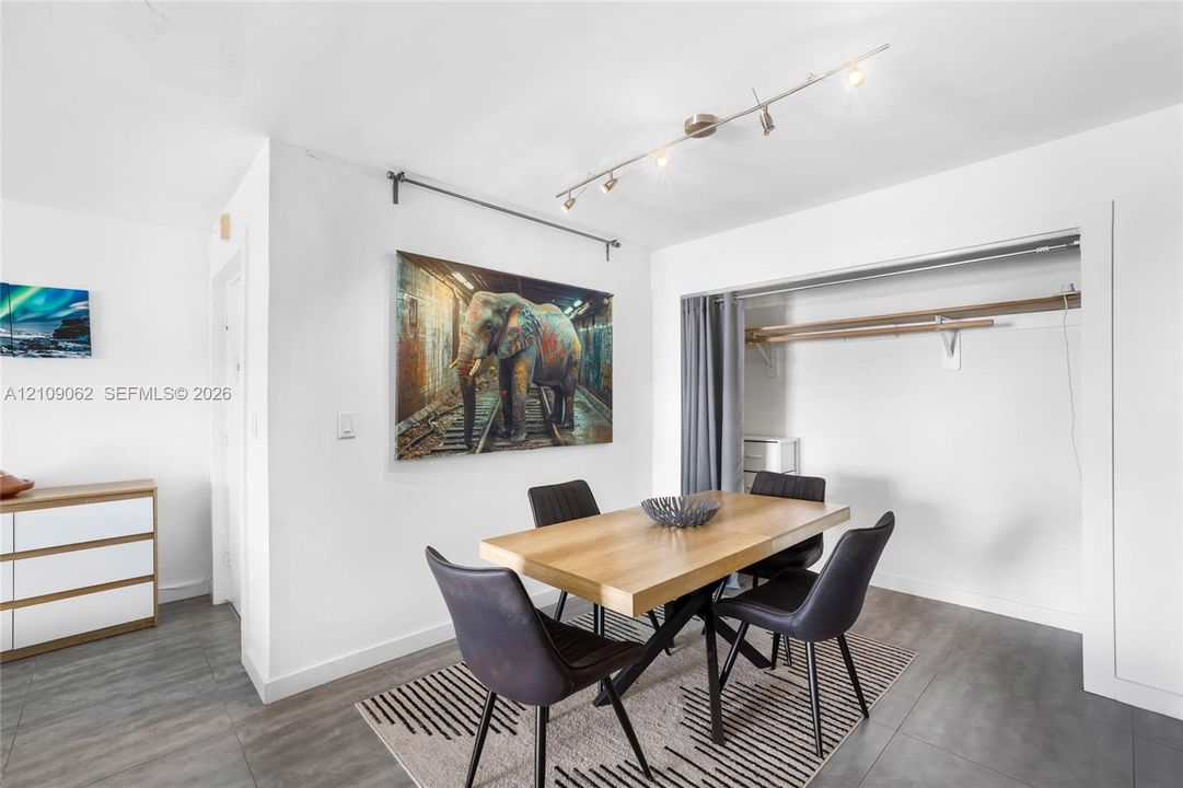 Wood-finish flooring, adjustable track lighting, and a reach-in closet with built-in shelving and a clothing rod
