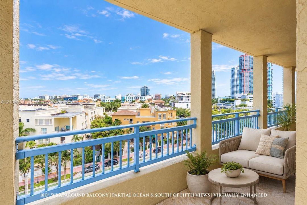 Covered wrap-around balcony featuring stone flooring, stucco columns, and a blue metal railing with expansive cityscape surroundings