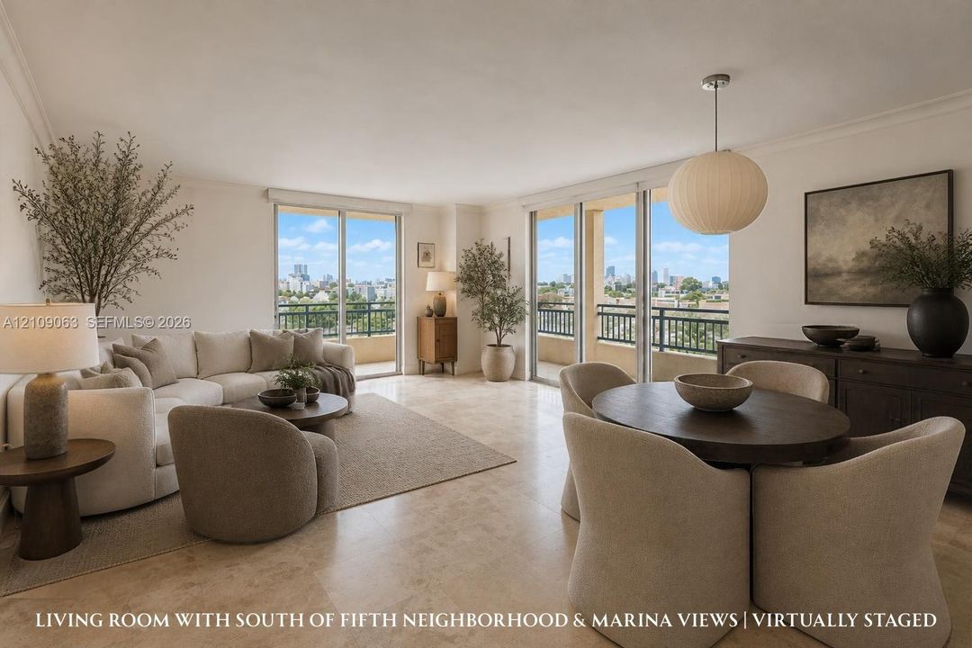 Open-concept interior featuring light-toned stone tile flooring, dual floor-to-ceiling glass sliding doors, a suspended spherical light fixture, and an expansive covered balcony with metal railing