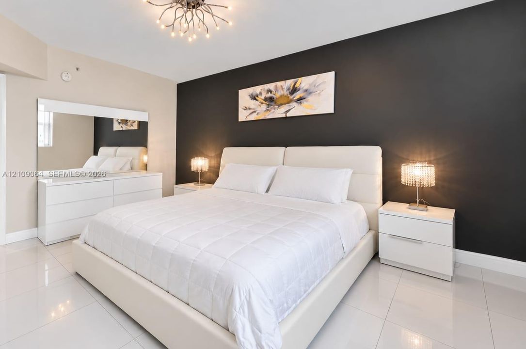 Polished tile flooring, contrast charcoal accent wall, and geometric branch-style chandelier