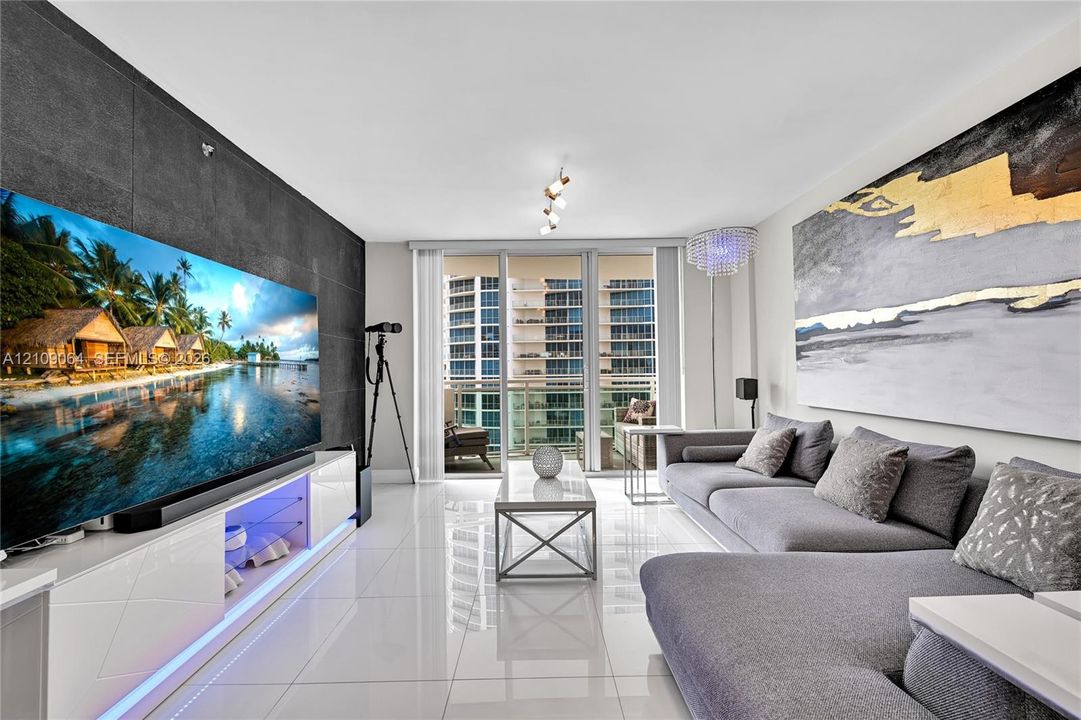 Large-format tile flooring, textured charcoal accent wall, glass balcony door system, and multi-directional track lighting