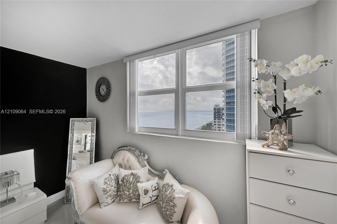 Dual-pane window with vertical blinds, crisp grey wall paint, and bold black accent wall