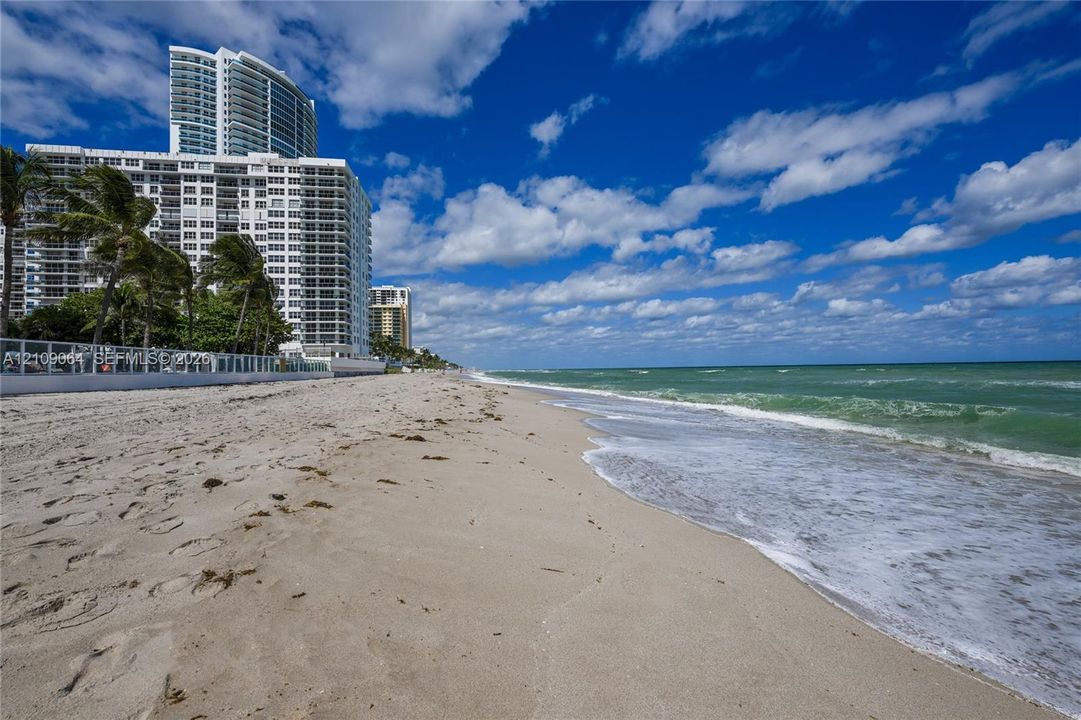 Direct oceanfront access with sandy beach frontage and perimeter security fencing