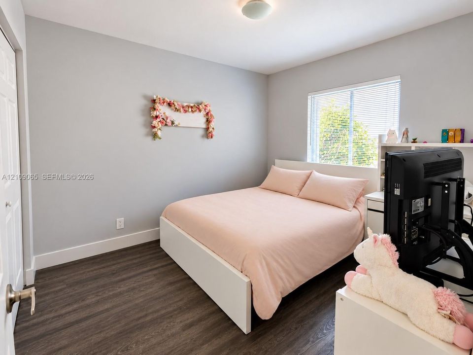 Neutral-toned walls, wood-finish flooring, and natural light from a double-pane window