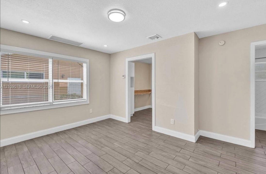 Neutral-toned interior featuring wood-finish flooring, recessed lighting, and a flush-mount ceiling fixture