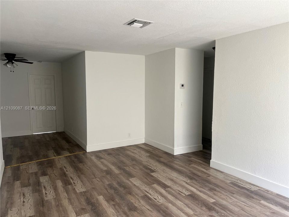 Interior space featuring wood-finish flooring, white walls, and a ceiling-mounted light fixture