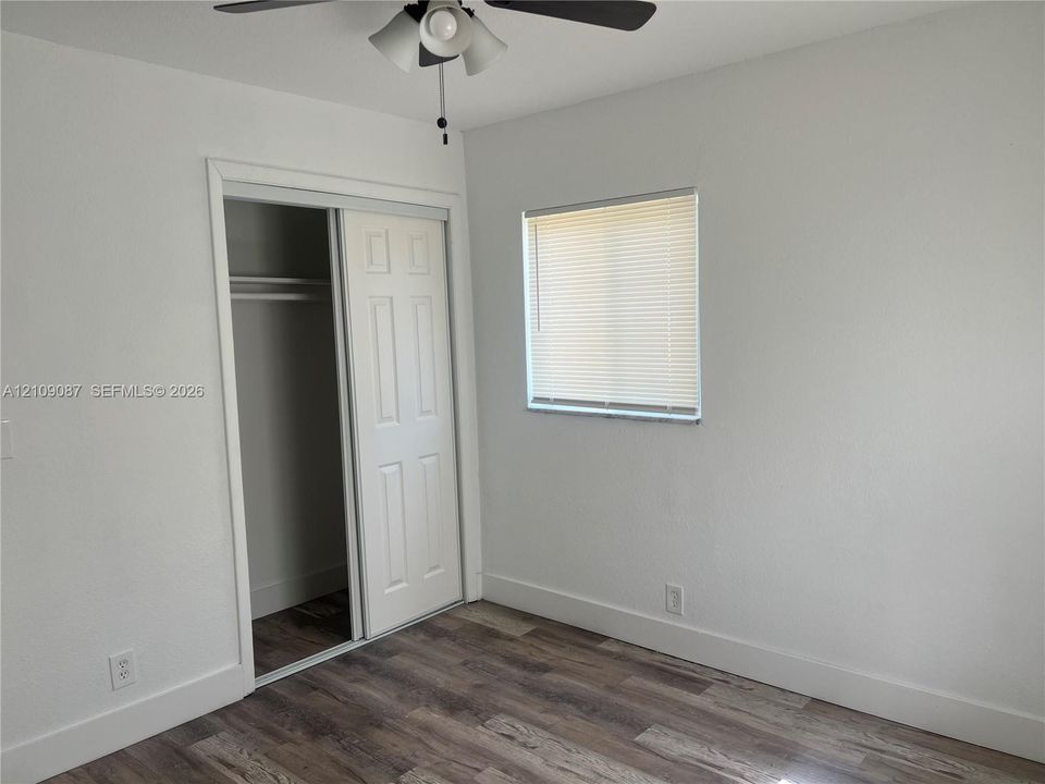 Wood-finish flooring, sliding closet door, and ceiling fan with integrated lighting