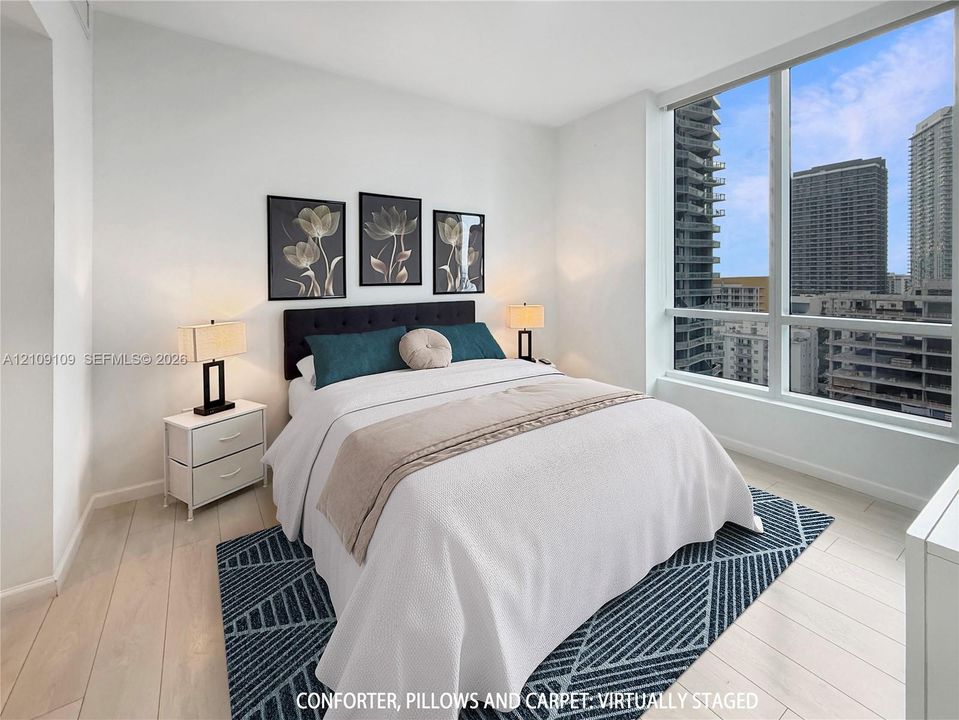 Floor-to-ceiling windows with urban exposure, light-toned wood-finish flooring, and crisp white wall finishes