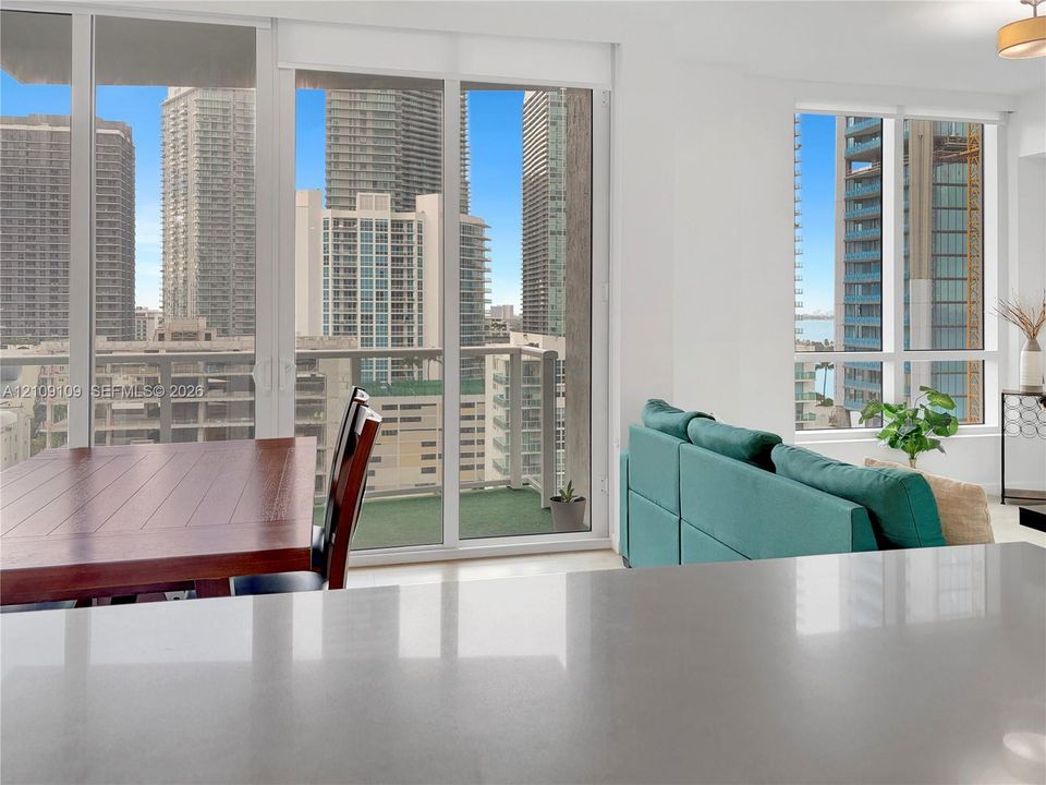 Floor-to-ceiling windows, private balcony, quartz countertop, and neutral interior finishes