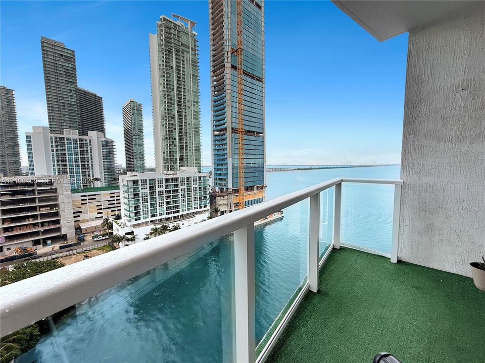 Private balcony featuring a glass panel railing and water surroundings