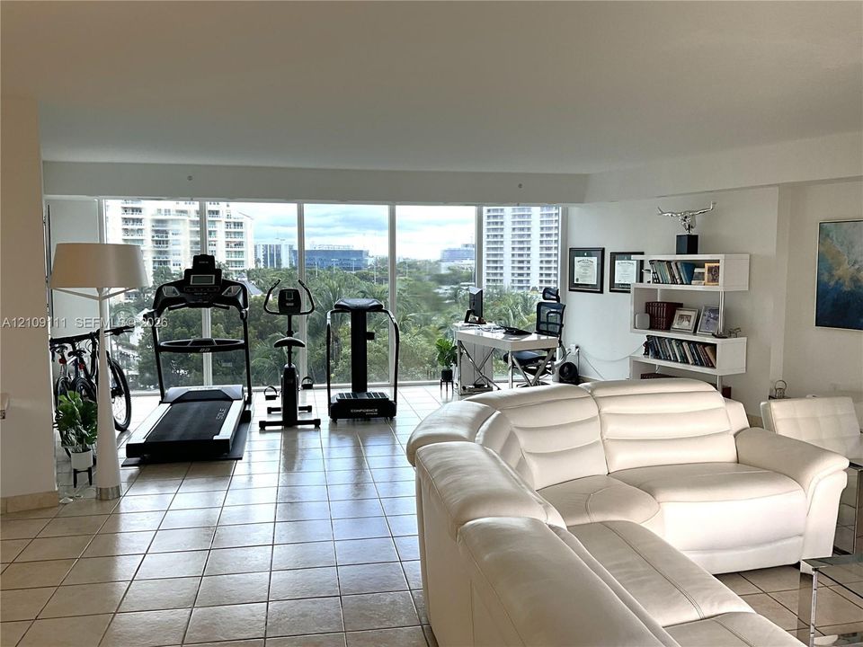 Open-concept interior featuring large-format ceramic tile flooring and expansive floor-to-ceiling windows