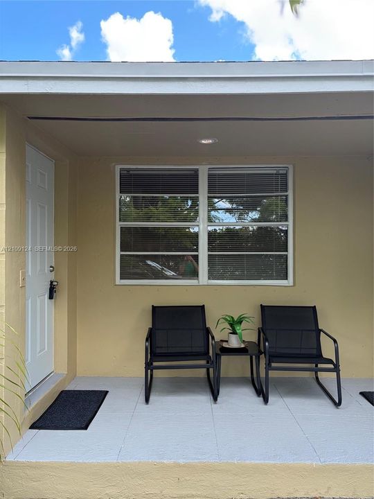 Covered porch featuring painted concrete flooring, recessed lighting, and a white paneled entry door