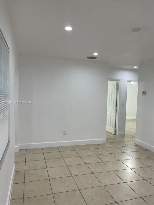 Neutral-toned tile flooring, recessed ceiling lighting, and interior six-panel doors