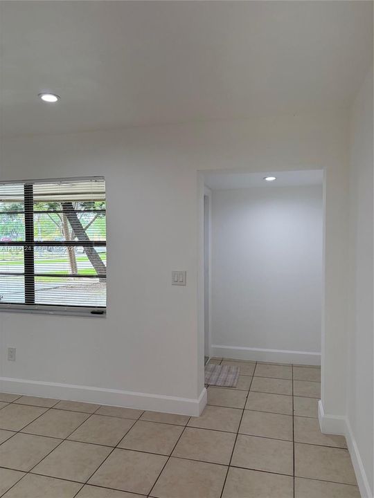 Neutral-toned ceramic tile flooring, recessed lighting, and a multi-pane horizontal window