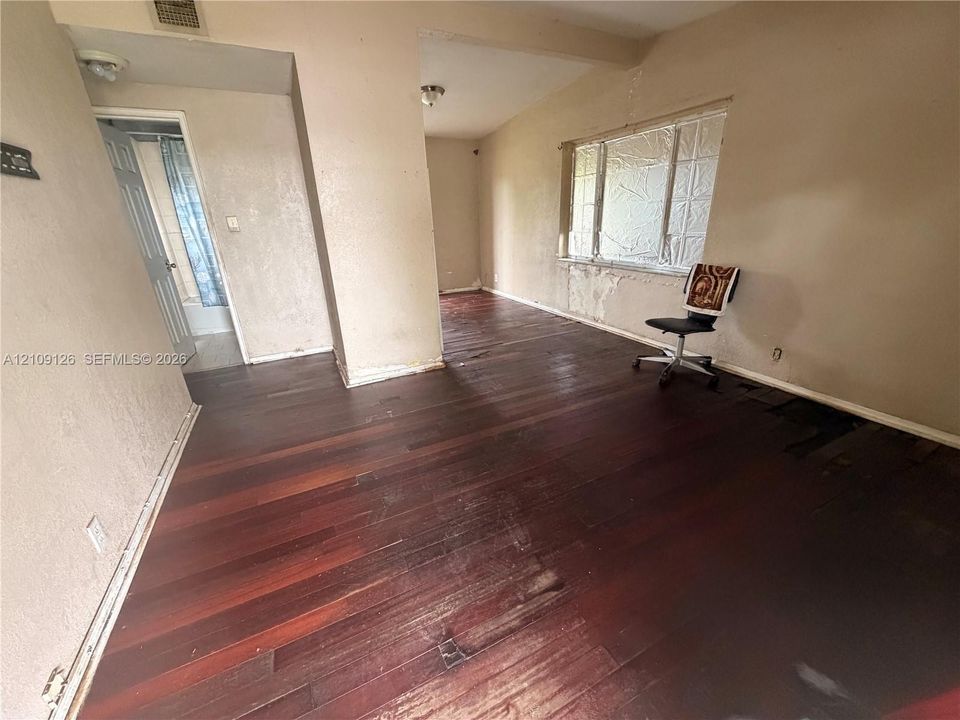 Interior space featuring dark wood-finish flooring and a multi-pane window
