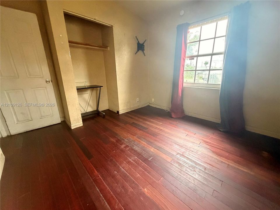 Wood-finish flooring, multi-pane window, and built-in closet with shelving