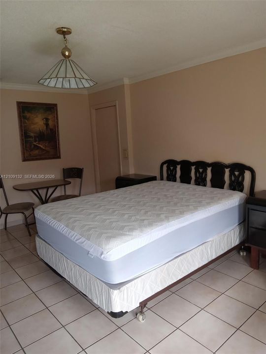 Ceramic tile flooring, crown molding, and geometric pendant lighting