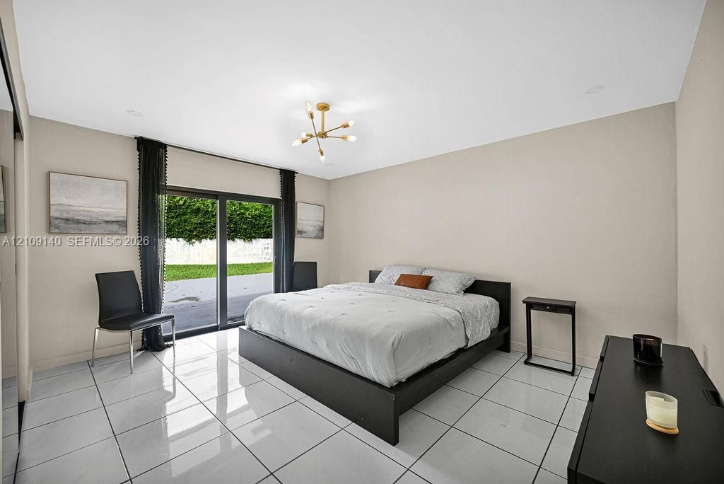 High-gloss tile flooring, sliding glass door, recessed lighting, and multi-arm geometric ceiling fixture
